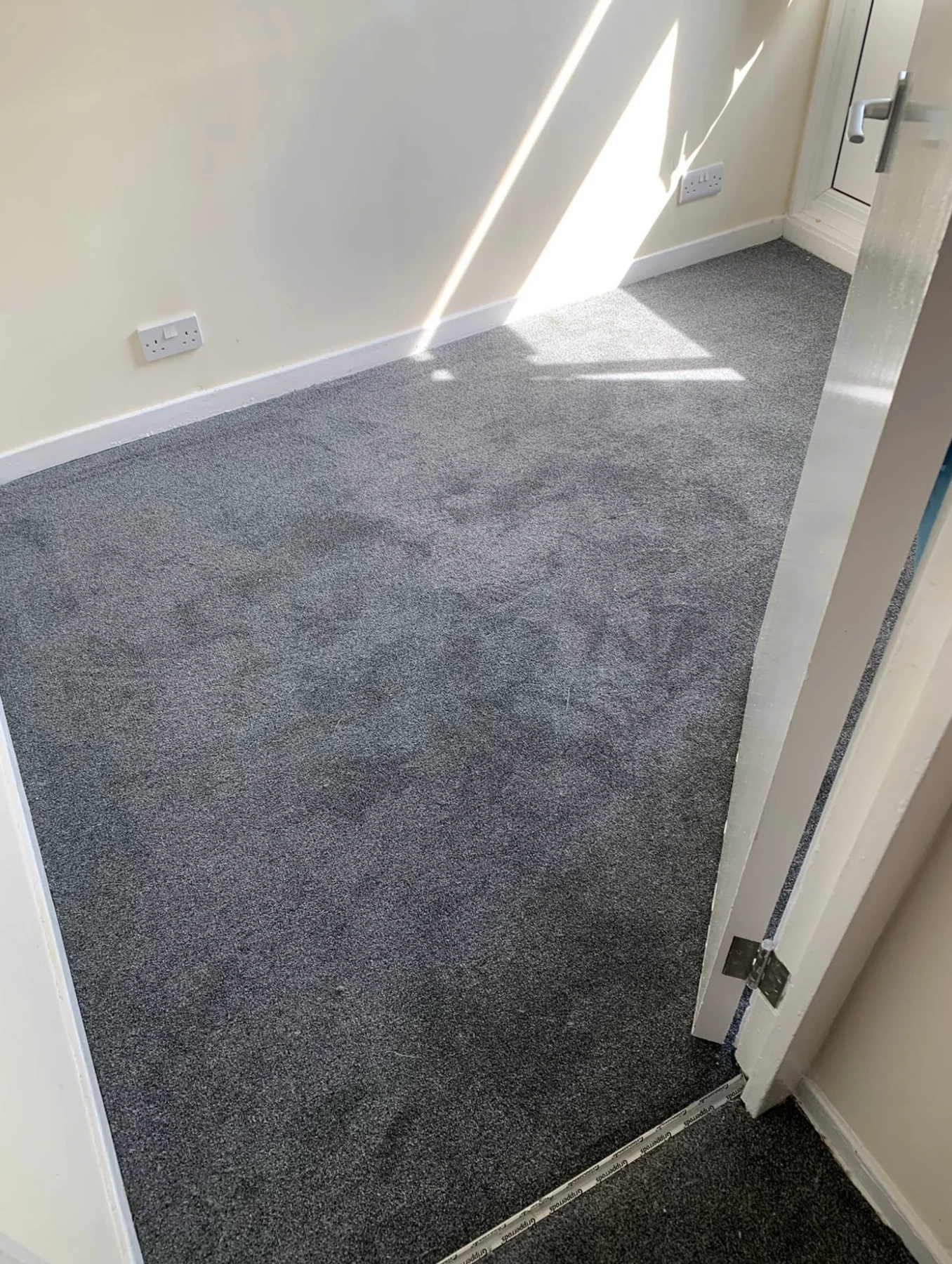 Grey carpet fitted in a bright room